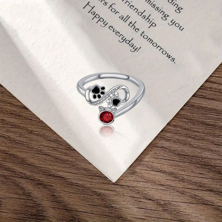 Anillo Ajustable con Diseño de Huellas de Pata Negras y Piedra Roja