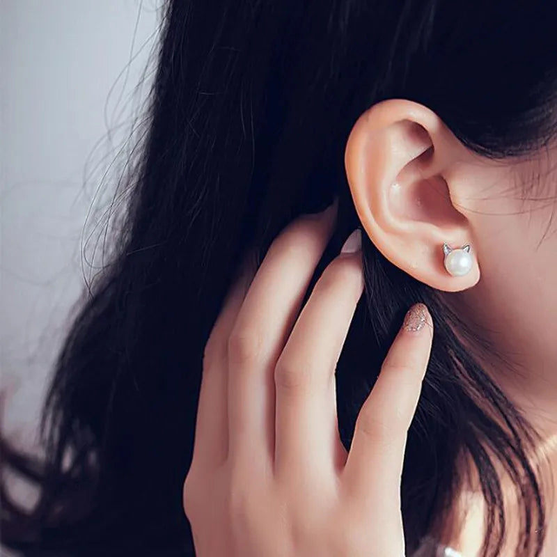 "Pendientes de Gato en Plata Esterlina con Perlas" puede reescribirse como "Pendientes de Stud de Gato de Plata con Perlas".
