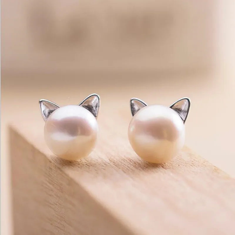 "Pendientes de Gato en Plata Esterlina con Perlas" puede reescribirse como "Pendientes de Stud de Gato de Plata con Perlas".